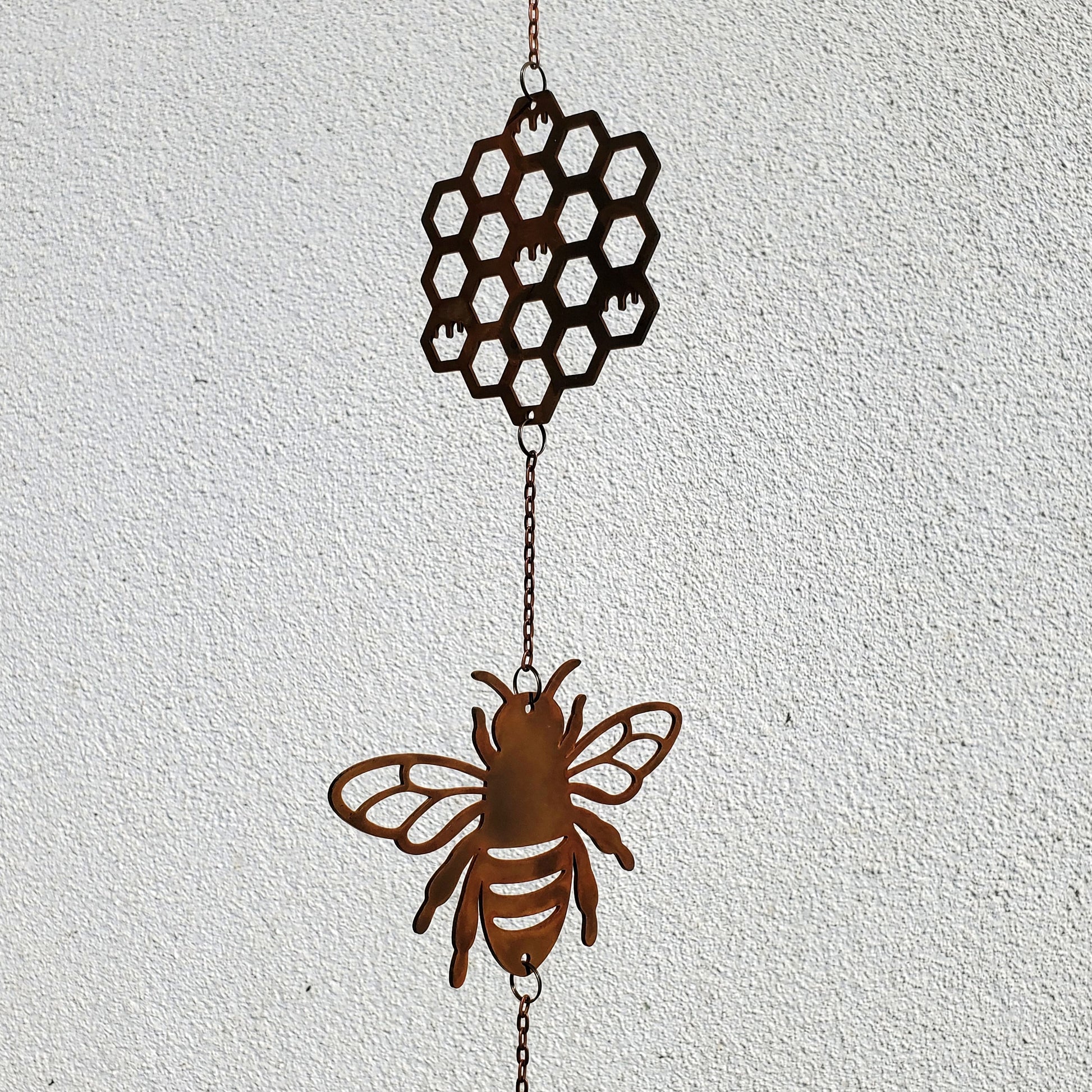 Close-up detail of the hexagonal honeycomb patterns on the 14-gauge rusted steel wind spinner, highlighting precise laser-cut edges